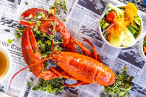 Lobster On Newspaper and A Side of Vegetables Lobster On Newspaper and A Side of Vegetables